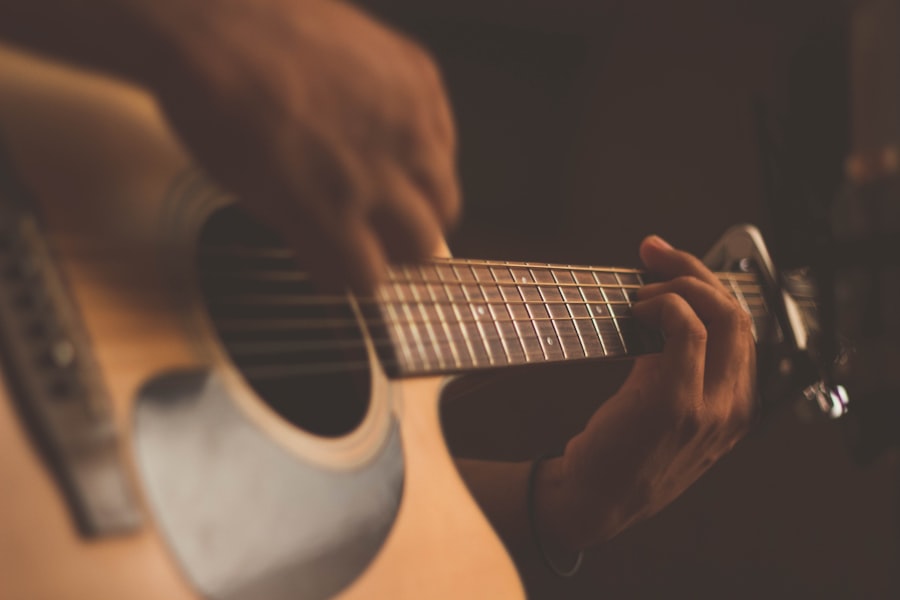 Hands fretting and strumming an acoustic guitar